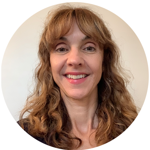 Lisa is smiling for a selfie in front of a cream-coloured wall.